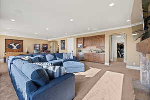 Living area featuring light colored carpet, recessed lighting, baseboards, arched walkways, and wet bar