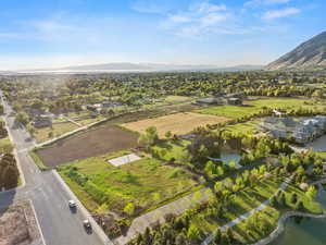 Aerial view of property and surrounding area featuring nearby suburban area and a water and mountain view