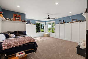 Bedroom with a decorative wall, recessed lighting, carpet floors, wainscoting, and ceiling fan