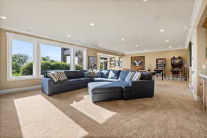 Living room with light carpet, crown molding, recessed lighting, and baseboards