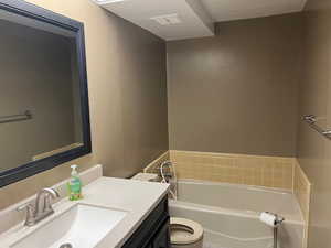 Full bath featuring a garden tub, vanity, and toilet