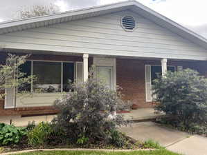 View of front of property with brick siding and a porch