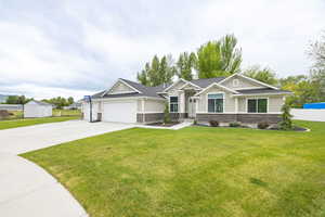 Craftsman house with stone siding, concrete driveway, board and batten siding, an attached garage, and roof with shingles