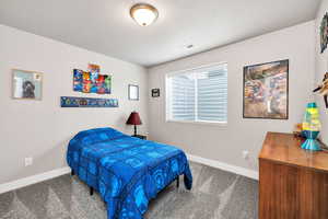 Bedroom with baseboards, carpet, and a textured ceiling