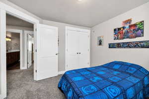 Carpeted bedroom with a closet and a textured ceiling