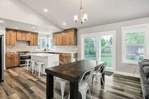 Kitchen featuring appliances with stainless steel finishes, backsplash, recessed lighting, dark wood-style floors, and lofted ceiling