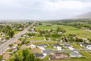 Aerial view of property and surrounding area featuring a mountain backdrop and nearby suburban area
