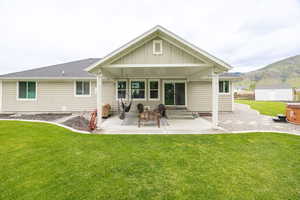 Back of property with a patio area, a storage unit, a yard, and an outdoor structure