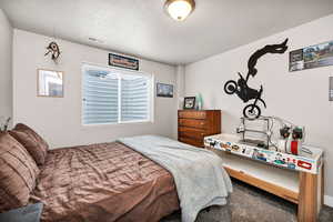 Carpeted bedroom featuring a textured ceiling