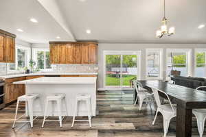 Kitchen featuring brown cabinetry, light countertops, decorative backsplash, dark wood finished floors, and recessed lighting