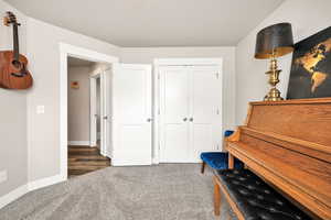 Sitting room featuring carpet flooring and baseboards