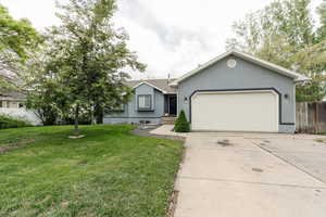Single story home with stucco siding, driveway, and an attached garage