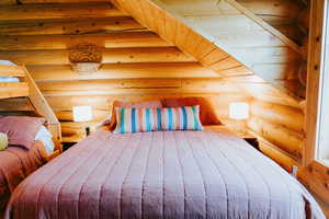 Bedroom featuring rustic walls