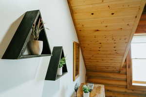 Bonus room featuring rustic walls, wooden ceiling, and vaulted ceiling