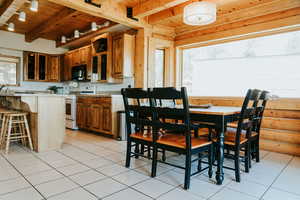 Kitchen featuring gas range gas stove, wooden ceiling, black microwave, beamed ceiling, and light countertops