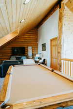Rec room featuring wooden ceiling, lofted ceiling, and log walls