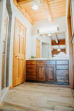 Full bath featuring beamed ceiling, wood ceiling, wood finished floors, vanity, and a stall shower