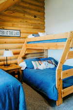 Carpeted bedroom with rustic walls