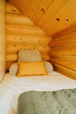 Bedroom featuring rustic walls, lofted ceiling, and wooden ceiling