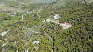 Aerial view of property and surrounding area with a forest