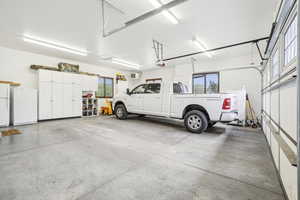 Garage featuring refrigerator, freestanding refrigerator, and a garage door opener