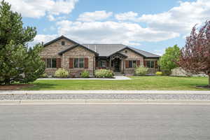 Craftsman-style home with brick siding and a front yard