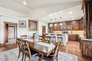Dining area with light wood-type flooring, lofted ceiling, and recessed lighting