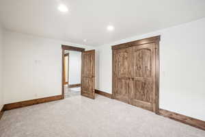 Unfurnished bedroom with carpet, baseboards, and recessed lighting