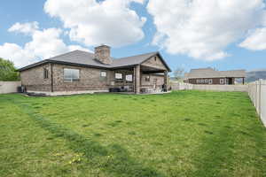 Rear view of property featuring brick siding, a chimney, a patio area, central air condition unit, and a shingled roof