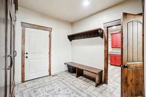 Mudroom with light stone finish flooring and recessed lighting