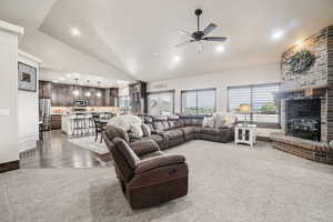Living room with lofted ceiling, a ceiling fan, dark carpet, recessed lighting, and baseboards