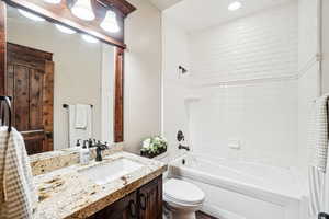 Full bathroom with toilet, bathtub / shower combination, vanity, and recessed lighting