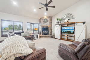 Living room with vaulted ceiling, a fireplace, a ceiling fan, carpet floors, and recessed lighting