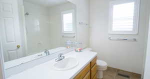 Full bathroom with toilet, vanity, tile patterned flooring, a shower, and baseboards
