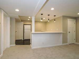 Kitchen featuring freestanding refrigerator, carpet flooring, recessed lighting, baseboards, and decorative light fixtures