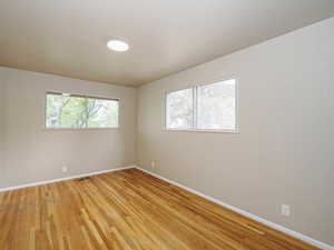 Spare room featuring baseboards and light wood finished floors