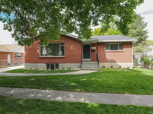Single story home with brick siding and a front lawn