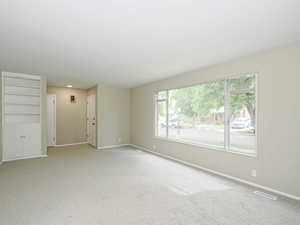 Spare room featuring baseboards and light colored carpet