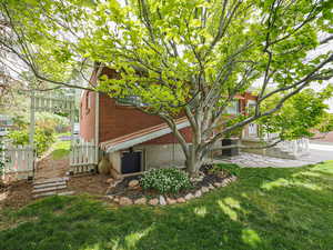 View of property exterior with brick siding, a yard, and central air condition unit