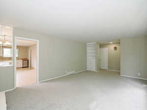 Spare room with baseboards and light colored carpet