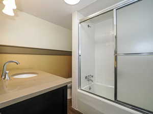 Bathroom with combined bath / shower with glass door and vanity