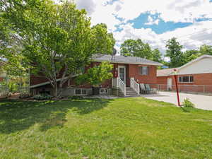 Back of property with entry steps, brick siding, and a patio