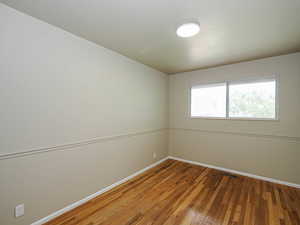 Empty room featuring baseboards and hardwood / wood-style flooring
