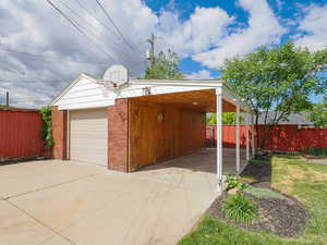 Garage with driveway, fence, and a garage