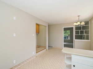Unfurnished dining area with light carpet, a chandelier, and baseboards