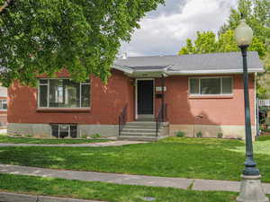 View of front of property with a front yard and brick siding