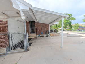 Side entrance to kitchen or basement area , a carport, and a gate