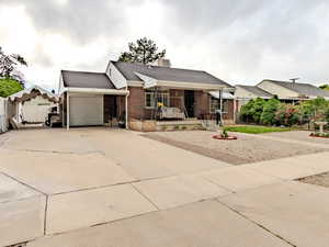 Ranch-style house with brick siding, an attached garage, concrete driveway, roof with shingles, and a chimney