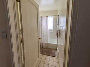 Full bathroom featuring tile patterned flooring and shower / bath combo with shower curtain