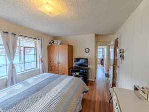 Bedroom featuring a textured ceiling and wood finished floors